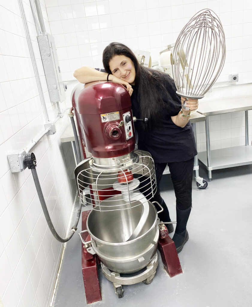 Maiden Voyage Catering Staff next to giant industrial kitchen mixer